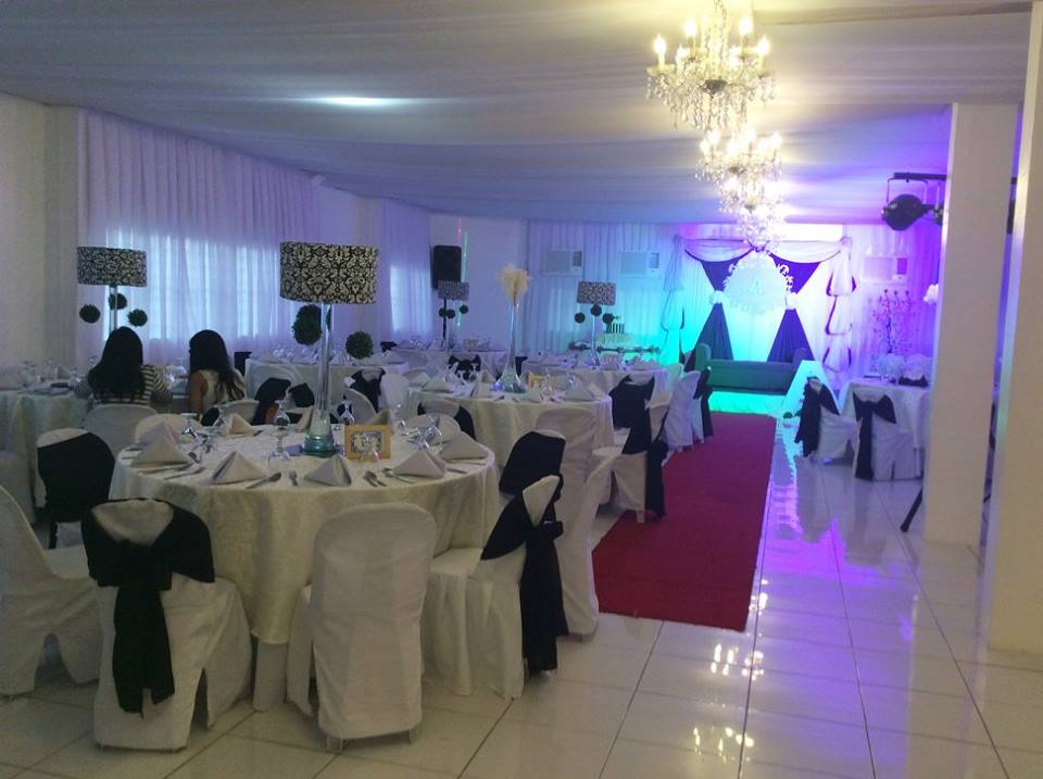 Events place in a function room decorated with purple lights and white chandeliers