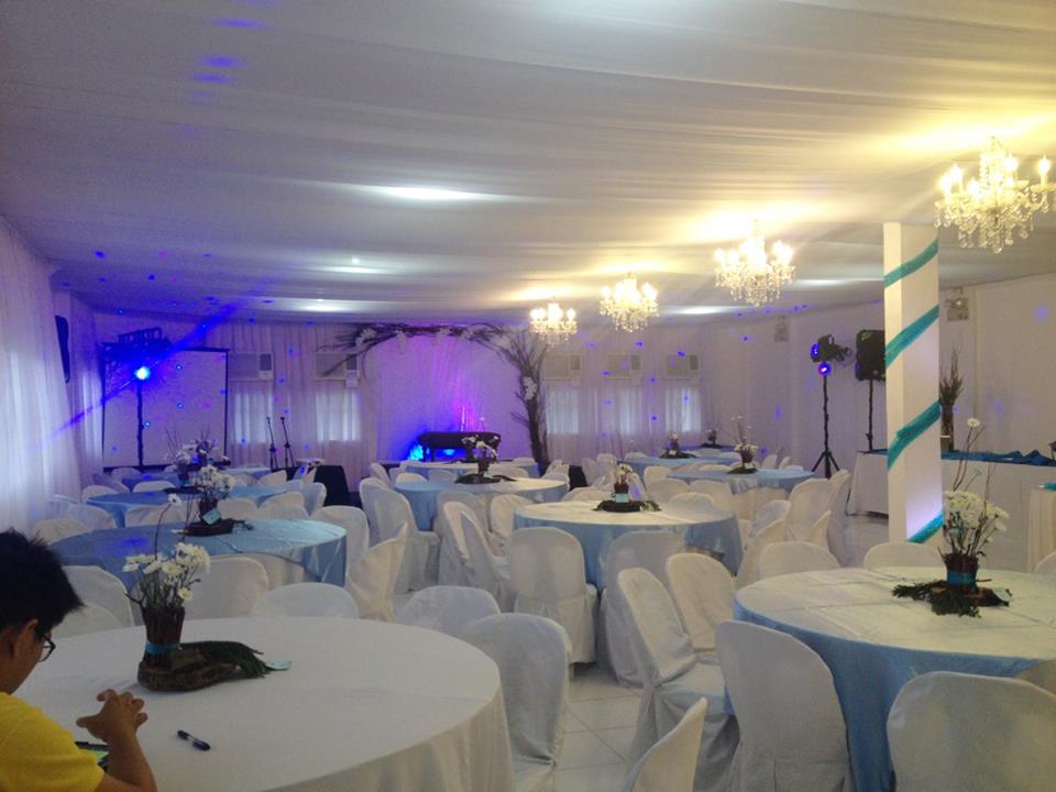Events place in a function room decorated with blue lights and white chandeliers