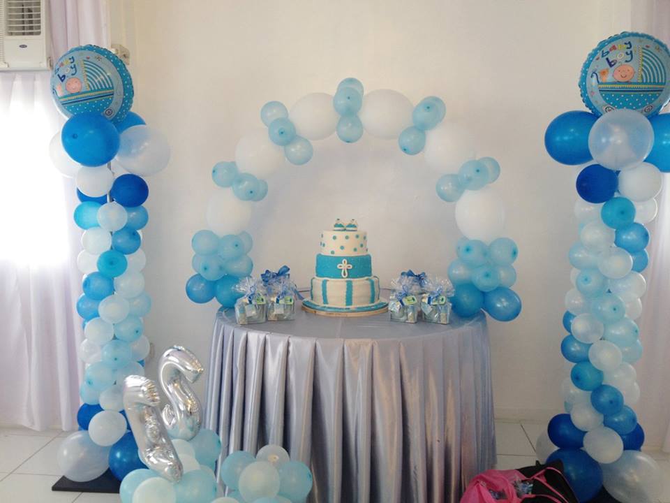 Table decorated with blue and white balloons, gifts and a cake