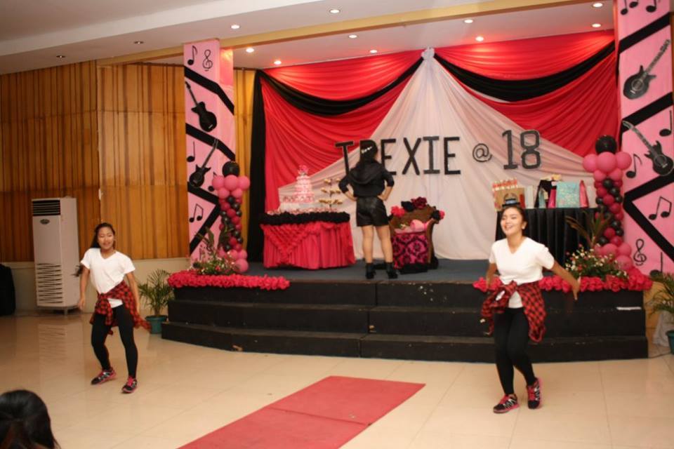 Dance number of three girls on stage of an 18th debut birthday decorated with black and red music theme
