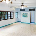 An empty living room with ceiling fan and wall painting