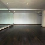 An empty room used for dance lessons with a huge mirror