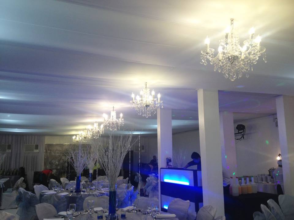 Function room decorated with blue lights and white chandelier
