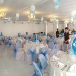 Function room decorated with balloons, blue and white theme, table and chairs setup